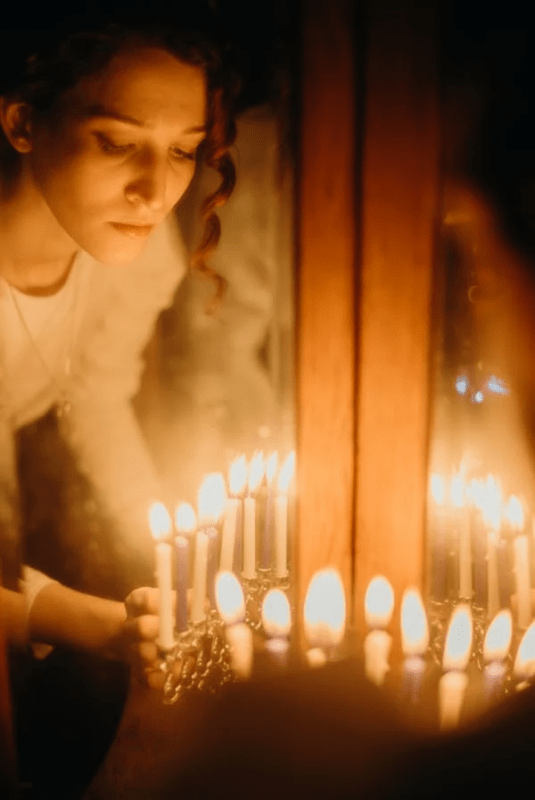 A woman lighting a candle in a church